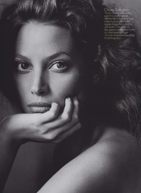 Striking black and white portrait of Christy Turlington with dark wavy hair, her chin resting on her hand in a classic pose.