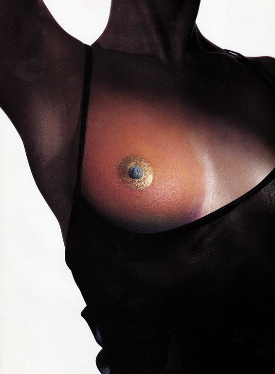 Close-up of a person wearing a black top with gold body paint highlighting the chest styled by Phyllis Posnick
