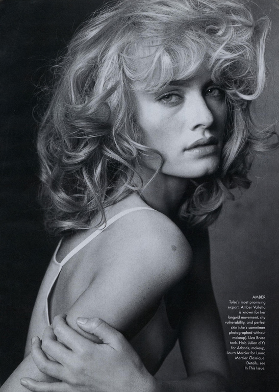 Black and white portrait of a woman with voluminous blonde hair looking over her shoulder, styled by Phyllis Posnick.