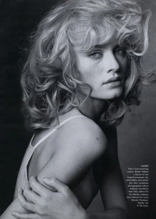 Black and white portrait of a woman with voluminous blonde hair looking over her shoulder, styled by Phyllis Posnick.