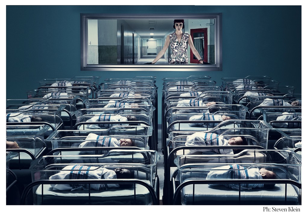 Stylized image of newborn babies in cribs in rows, with a woman in a window overlooking them in a hospital setting.