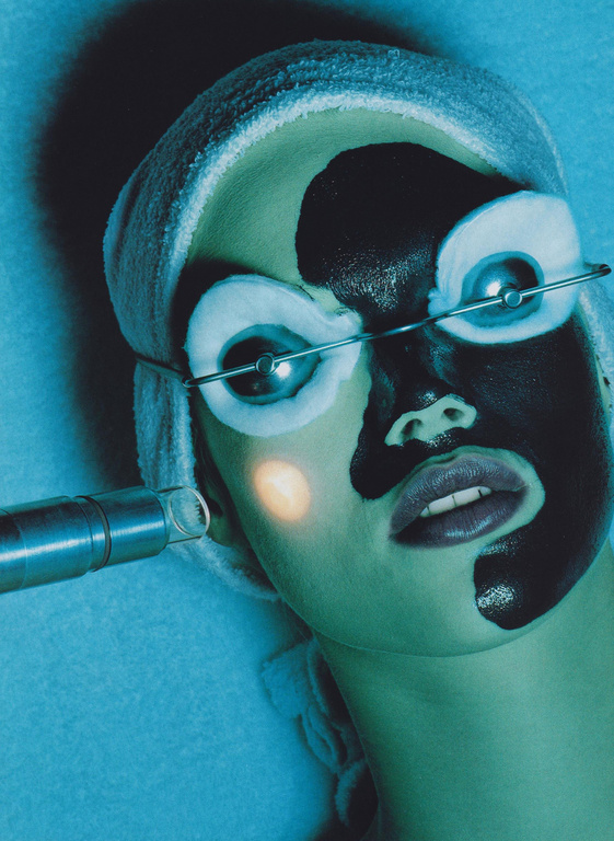Adult female receiving cosmetic laser treatment on face with protective eyewear and towel head wrap in a medical spa setting.