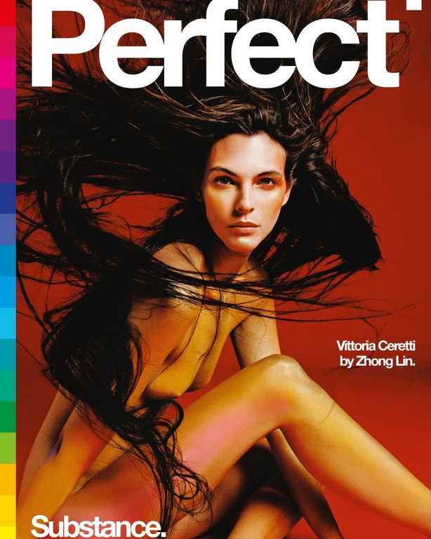 Elegant portrait of a nude fair-skinned adult female with long brown hair against a bold red backdrop for a magazine cover.