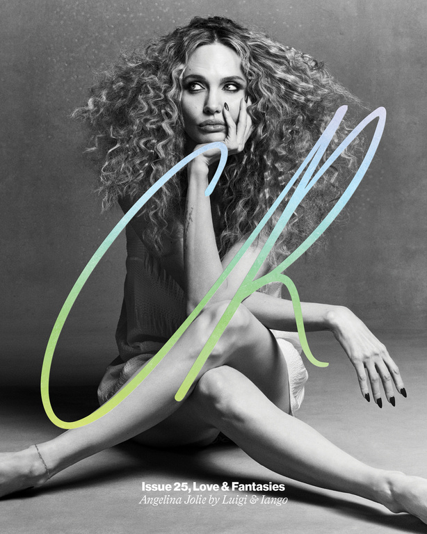 Angelina Jolie poses sitting with a gradient overlaid on a grey backdrop, featuring curly hair, neutral tones, and a serious expression.