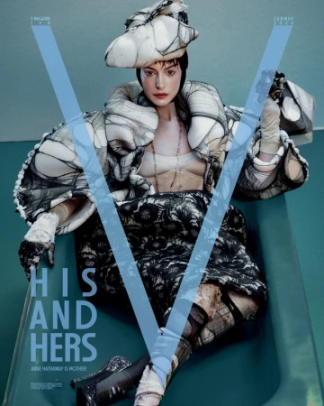 Anne Hathaway seated in a teal bathtub wearing an avant-garde black and white outfit with matching hat and gloves.