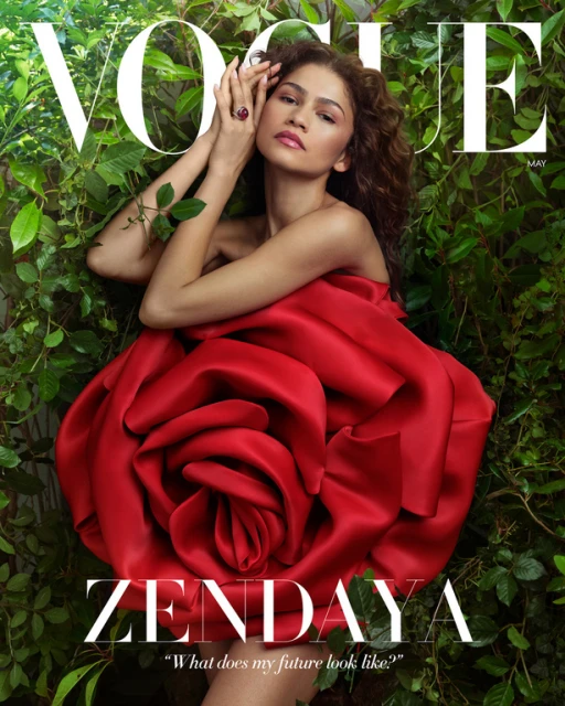 Vogue magazine cover featuring Zendaya wearing a red, rose-shaped dress, posing among green foliage with the Vogue logo at the top.