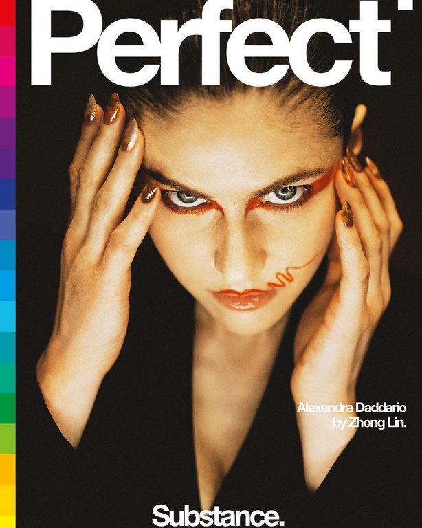 Close-up portrait of Alexandra Daddario on the cover of Perfect magazine, featuring dramatic makeup and a black blazer on a black background.