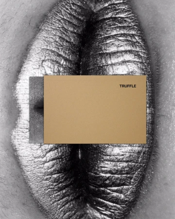 Close-up studio shot of female human body art in grayscale. A tan rectangle with the word TRUFFLE covers the body's center.