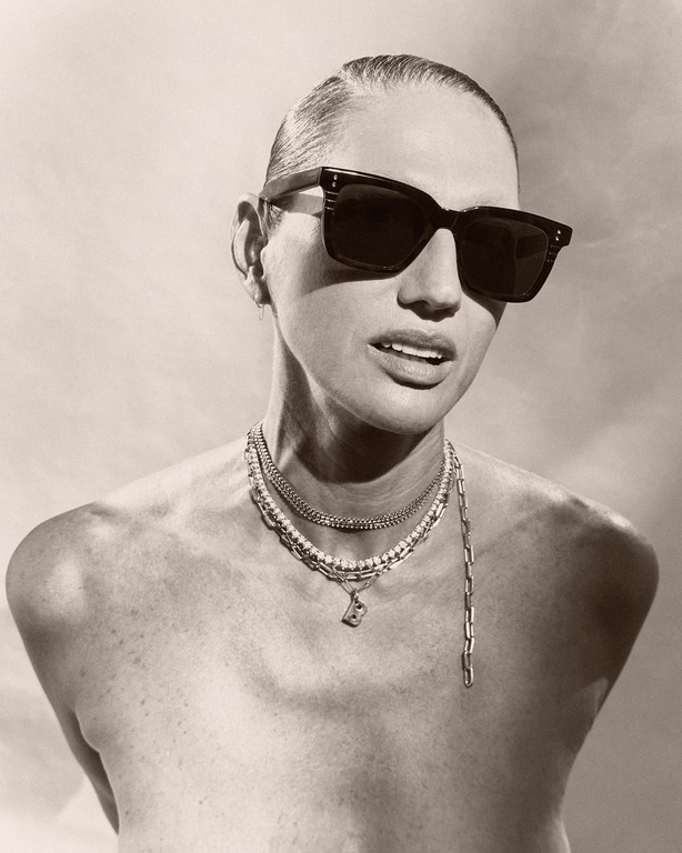 Monochrome portrait of a woman wearing dark sunglasses and layered necklaces, styled by Jezz Hill
