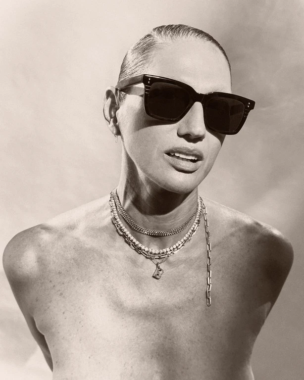 Monochrome portrait of a woman wearing dark sunglasses and layered necklaces, styled by Jezz Hill