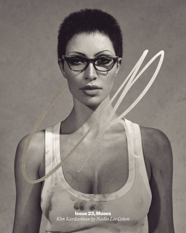 Black and white portrait of Kim Kardashian wearing glasses and a tank top for a magazine cover, shot in a photo studio.