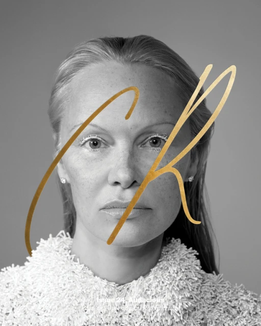 Black and white portrait of woman with fair skin, wearing a textured white top against a grey background with golden accents.