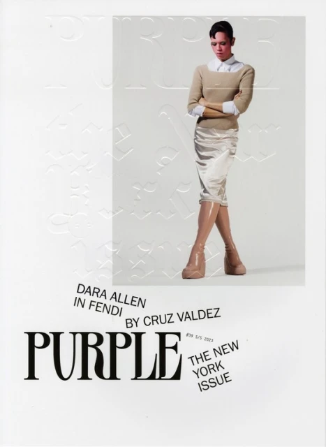 Magazine cover featuring a stylish woman in a tan sweater, cream skirt, and platform boots, posing in front of a textured white backdrop.