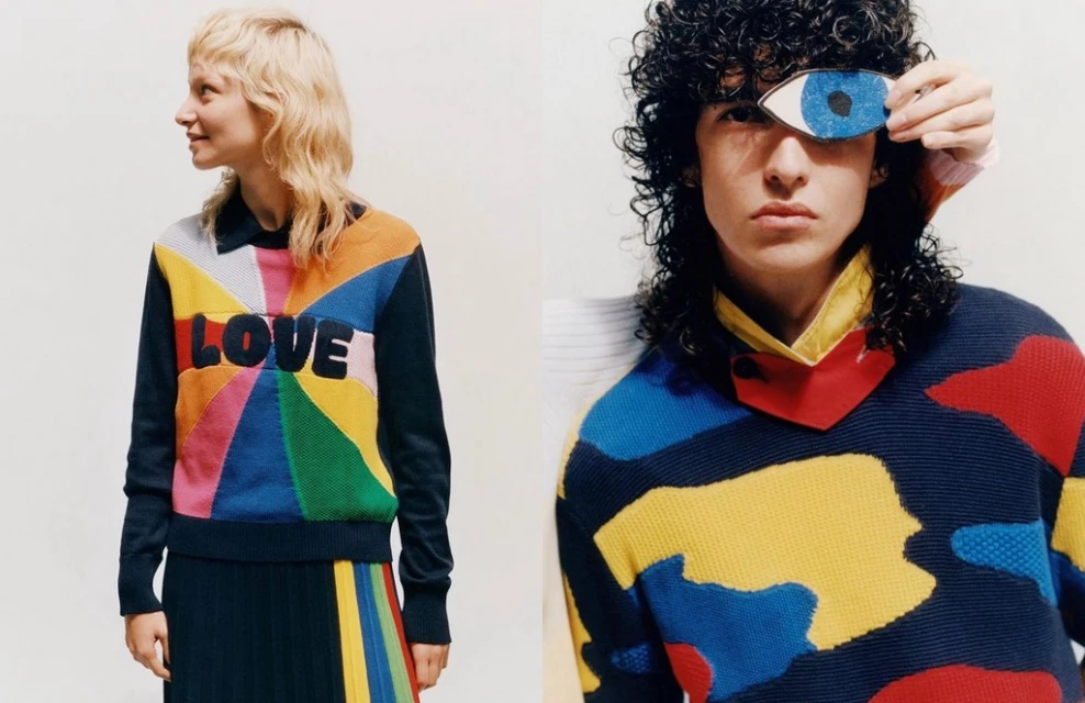 Two fashion models wearing colorful sweaters with vibrant geometric patterns and the word "LOVE" against a plain white background.
