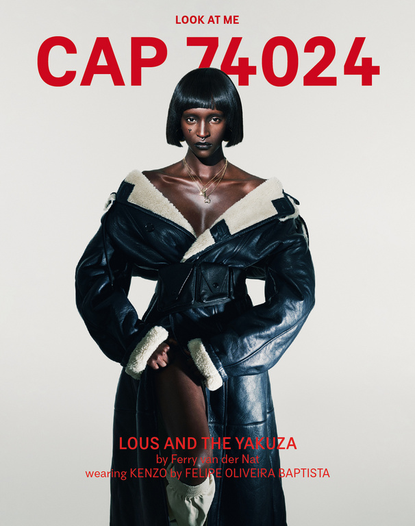 A dark-skinned woman in a black, oversized, shearling-lined coat stares at the camera against a neutral backdrop, with fashion magazine text.