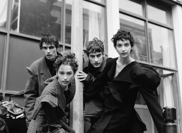 Monochrome portrait of four models posing outdoors near architectural elements, styled by hair stylist Jacob Kajrup
