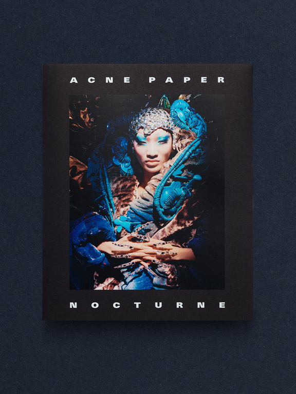 Cover of Acne Paper Nocturne featuring an ornate editorial portrait with blue makeup and sculptural headpiece.