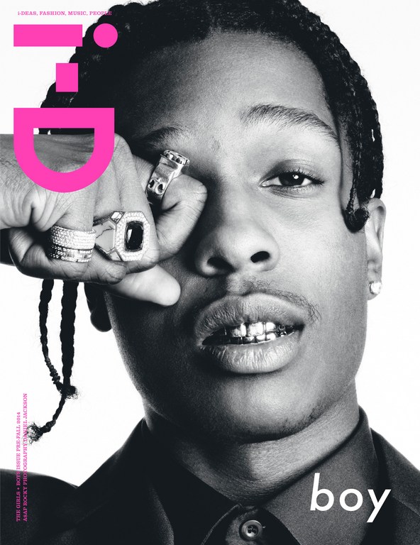 Black and white portrait of a young adult male with braided hair wearing rings, suit jacket, and gold teeth on a magazine cover.