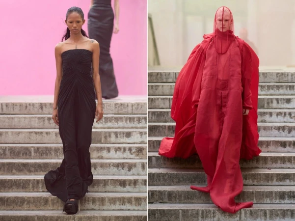 Two fashion models walking down outdoor stone stairs, one in a strapless black gown and one in a red veiled cloak