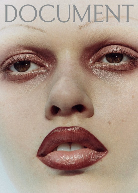 Close-up of a woman's face featuring prominent lips, brown eyes, and subtle makeup, with the word 'DOCUMENT' displayed on the upper side.
