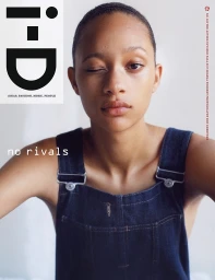 Close-up portrait of a young woman winking, wearing blue denim overalls against a plain white background with i-D magazine cover text.