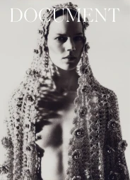Model wearing an ornate crocheted lace head covering and matching cape against a bright background with bold document text above