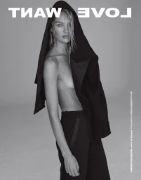 Model Candice Swanepoel wearing a black hooded jacket and trousers against a grey backdrop