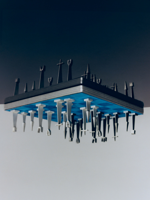 Elevated chess set with black and silver pieces suspended from a blue checkered board against a gradient gray backdrop.