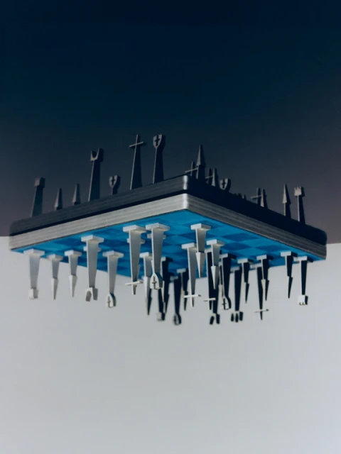 Elevated chess set with black and silver pieces suspended from a blue checkered board against a gradient gray backdrop.