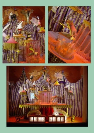 Whimsical window display with striped backdrop, featuring an assortment of playful bird figurines, miniature objects, and unique lighting.