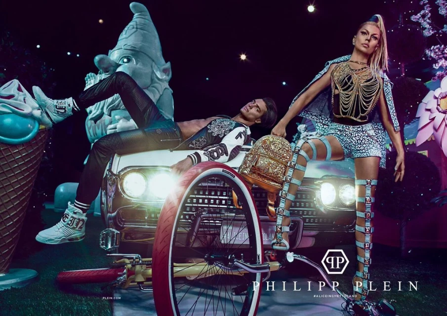Fashion shot in whimsical setting features two models, one lying on a car hood, the other standing, accessorized with a backpack, in night.