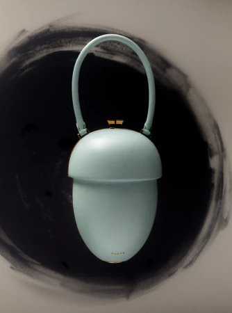 Light blue purse in an acorn shape with a curved handle and gold accents. The background features a circular, dark brushstroke pattern.