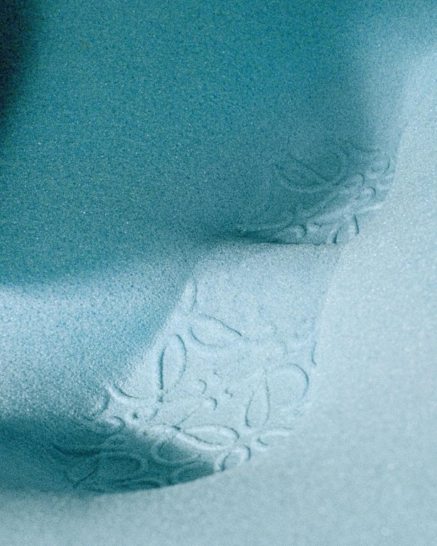 Close-up studio shot of a light-blue textured surface with a delicate floral pattern creating a soft, visually soothing effect.