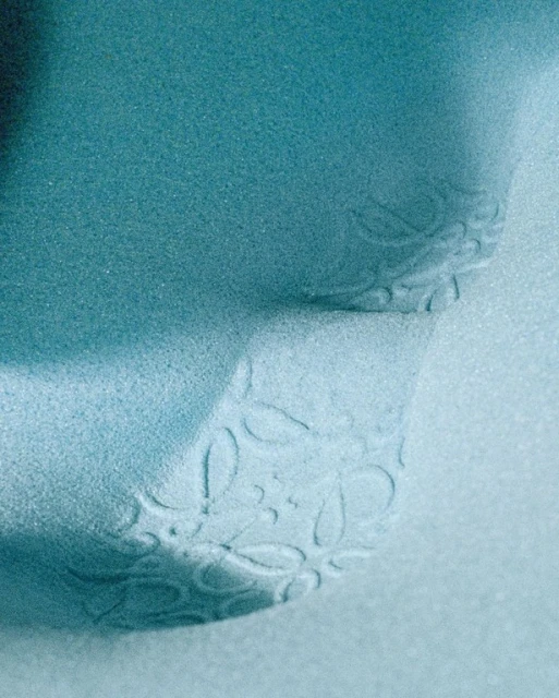 Close-up studio shot of a light-blue textured surface with a delicate floral pattern creating a soft, visually soothing effect.