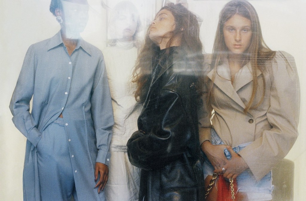 Fashion editorial featuring four women in stylish outfits; a blue shirt-pant set, a black leather jacket, and a beige blazer with denim shorts.