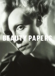 Close-up portrait of a woman with blonde hair in a vintage-style hairstyle and serious expression, styled by Jerry Stafford