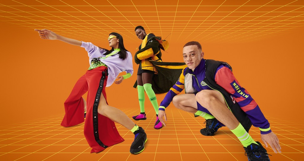 Three diverse models in stylish athletic wear pose dynamically against a vibrant orange grid backdrop, showcasing modern sportswear fashion.