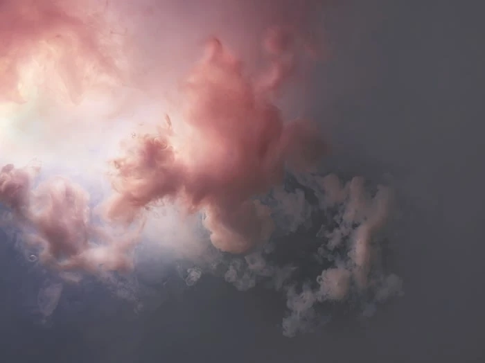 Dreamy cloudscape with soft pink and gray hues, creating a serene, abstract atmosphere. Perfect for backgrounds or atmospheric visuals.