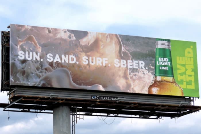 Billboard featuring Bud Light Lime, promoting a summer beach vibe with the slogans 'Sun. Sand. Surf. Sbeer.' and 'Live Limed'.