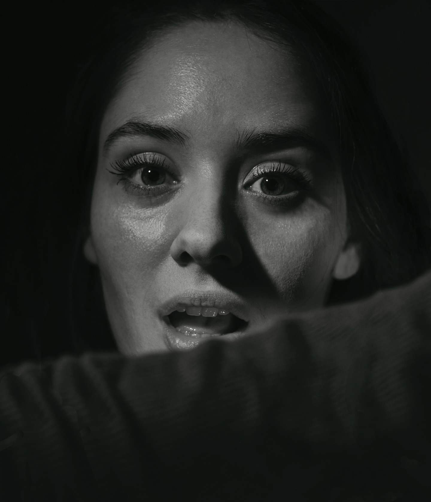 Close-up monochrome portrait of a woman looking upward with an expressive face, shot by Chris Buck.