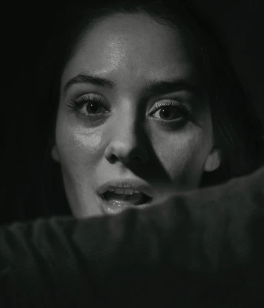Close-up monochrome portrait of a woman looking upward with an expressive face, shot by Chris Buck.