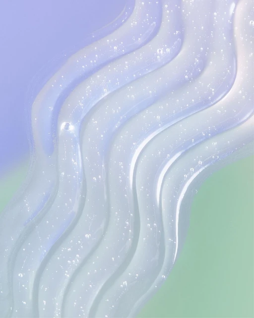 Transparent gel swirls against a two-toned background of purple and green, creating an abstract beauty or healthcare product image.
