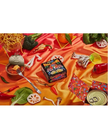 Still life featuring a colorful assortment of food items including a tin can, peppers, mushrooms, noodles, leafy greens, and mandarin oranges.