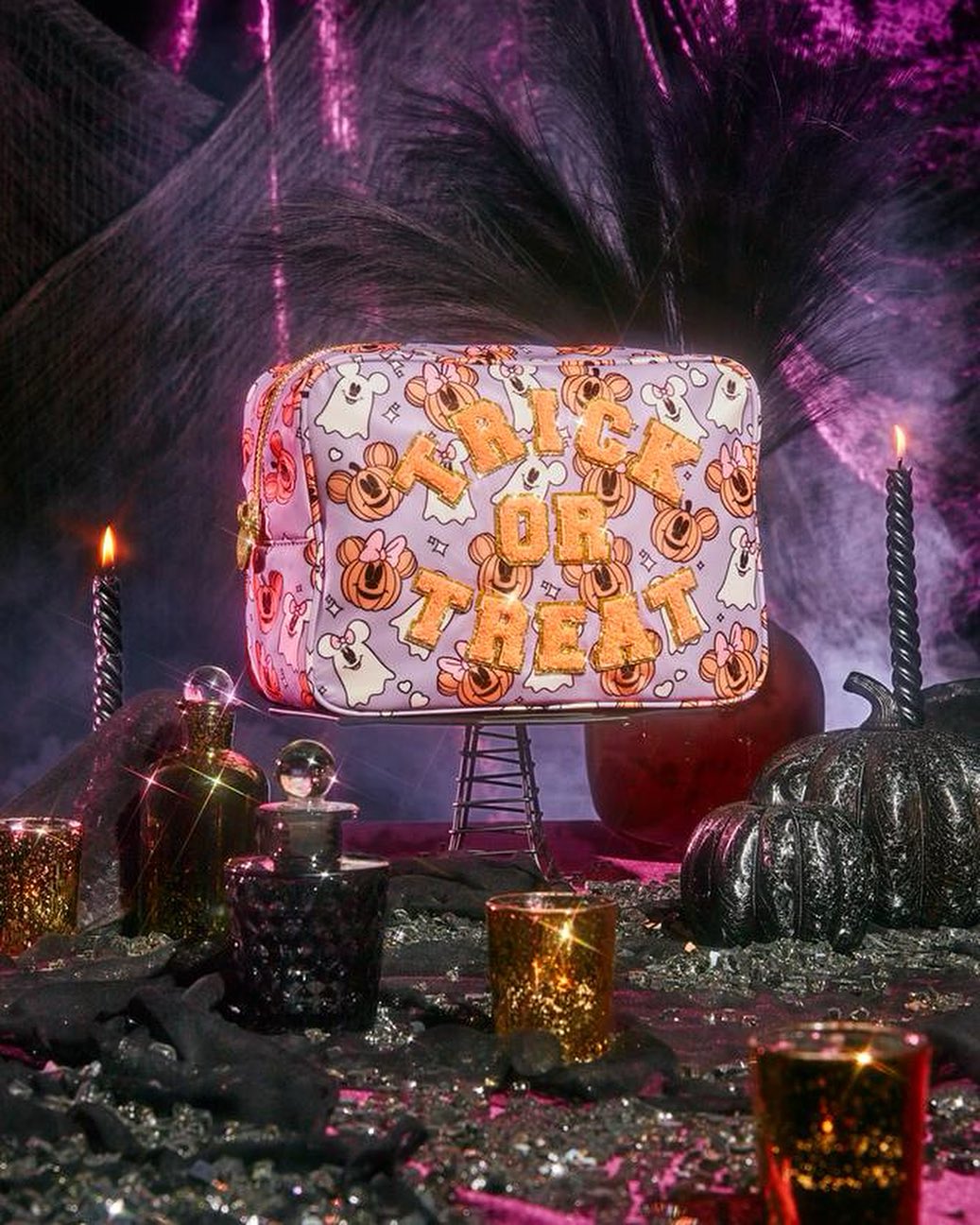 Halloween-themed makeup bag featuring Disney characters and 'Trick or Treat' text, set against a spooky background with candles and potions.