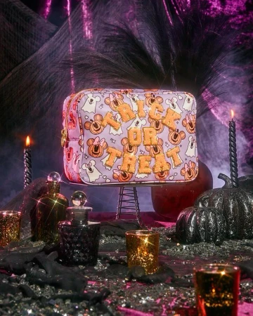 Halloween-themed makeup bag featuring Disney characters and 'Trick or Treat' text, set against a spooky background with candles and potions.