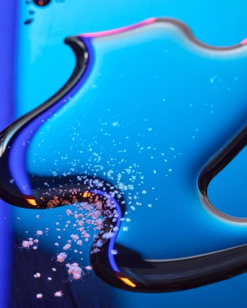 Abstract close-up of a smartphone with a blue screen and reflective curved edges, featuring scattered white powder.