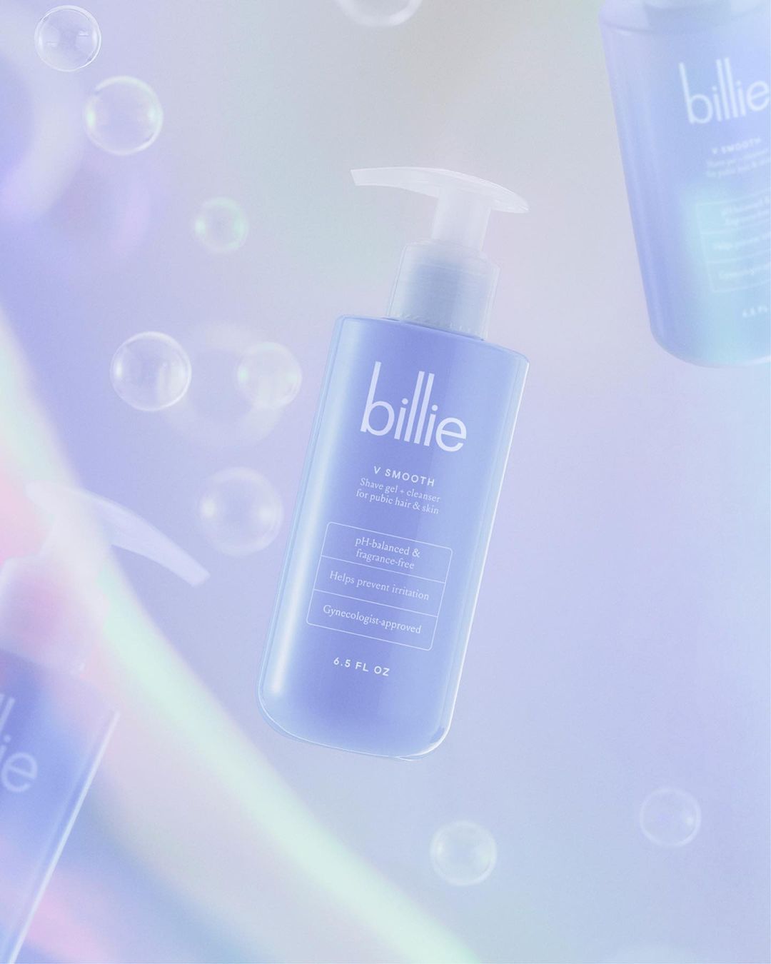 Billie V Smooth shave gel floats in a bubbly, bright, and airy studio shot. The purple bottle stands against a soft, colorful gradient.