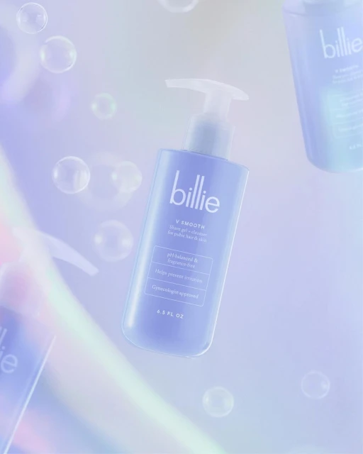 Billie V Smooth shave gel floats in a bubbly, bright, and airy studio shot. The purple bottle stands against a soft, colorful gradient.