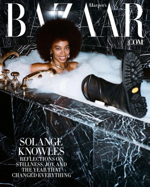 Fashion editorial featuring Solange Knowles in a marble bathtub filled with bubbles, Harper's Bazaar cover, with black work boots.