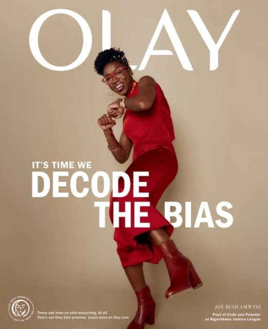 OLAY advertisement featuring a happy African-American woman in red dress and boots dancing in front of brand logo and mission statement.